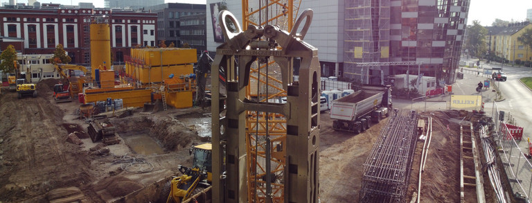 Der dekorative Header ist eine Aufnahme einer Baustelle in Düsseldorf. Im Vordergrund befindet sich der Ausschnitt eines Schlitzwandgreifers. Im Hintergrund befindet sich eine Betonitsuspensions-Aufbereitungsanlage.
