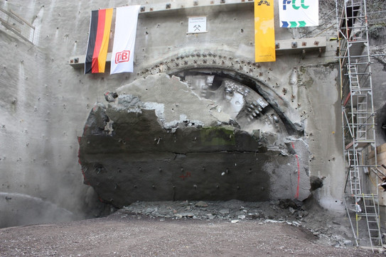 Tunneling breakthrough Zu sehen ist der Moment des Durchbruchs eines Tunnelvortriebs. An der Geländeoberfläche hängen u.a. die deutsche Flagge und die der DB.